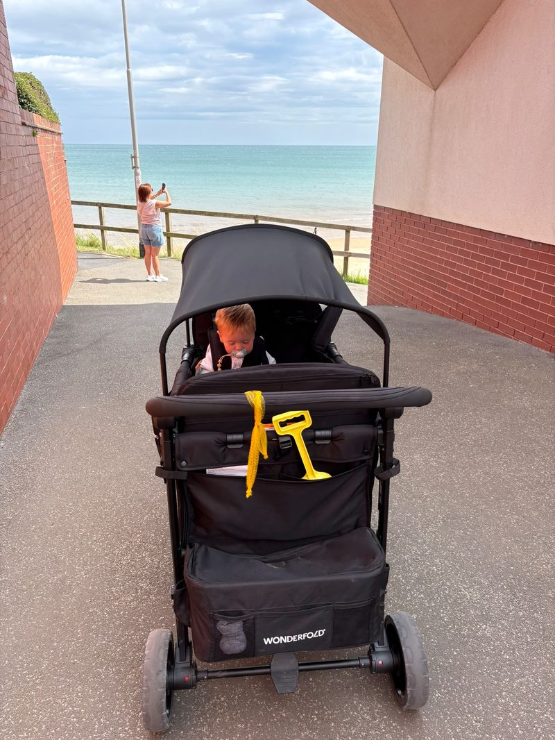 WonderFold wagon at the seaside with a toddler on board